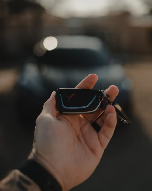 Reference photo of a smart car key fob held in a hand