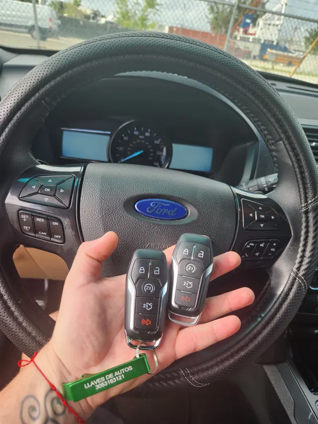 Two Ford remotes photographed at a Ford steering wheel